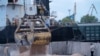 Punëtorët ngarkojnë grurë në një port në Izmail të Ukrainës, më 26 prill 2023.