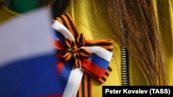 Илустрација - Жена ја носи лентата од Свети Ѓорѓија и боите на руското национално знаме.