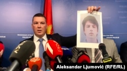 Ministar unutrašnjih poslova Filip Adžić drži fotografiju jednog od osumnjičenih Veljka Markovića za umiješanost u kupanje tunela do depoa Višeg suda u Podgorici.