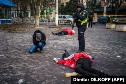 Un bărbat plânge lângă cadavrul unei femei ucise de un bombardament rusesc asupra orașului ucrainean Herson, pe 24 decembrie 2022.