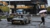 O femeie trece pe lângă o benzinărie distrusă de rachetele rusești, la Dnipro, pe 26 octombrie 2022. REUTERS / Mykola Synelnykov 