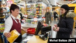 Egy vásárló Erzsébet-utalvánnyal fizet a kasszánál egy budapesti üzletben 2016. december 9-én