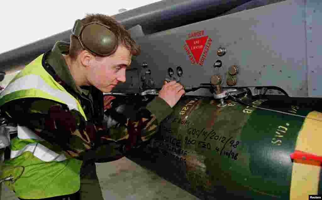 Një ushtar britanik duke kontrolluar raketat e një aeroplani Harrier GR7 në një bazë ushtarake në Itali, 27 mars 1999. Reuters. 