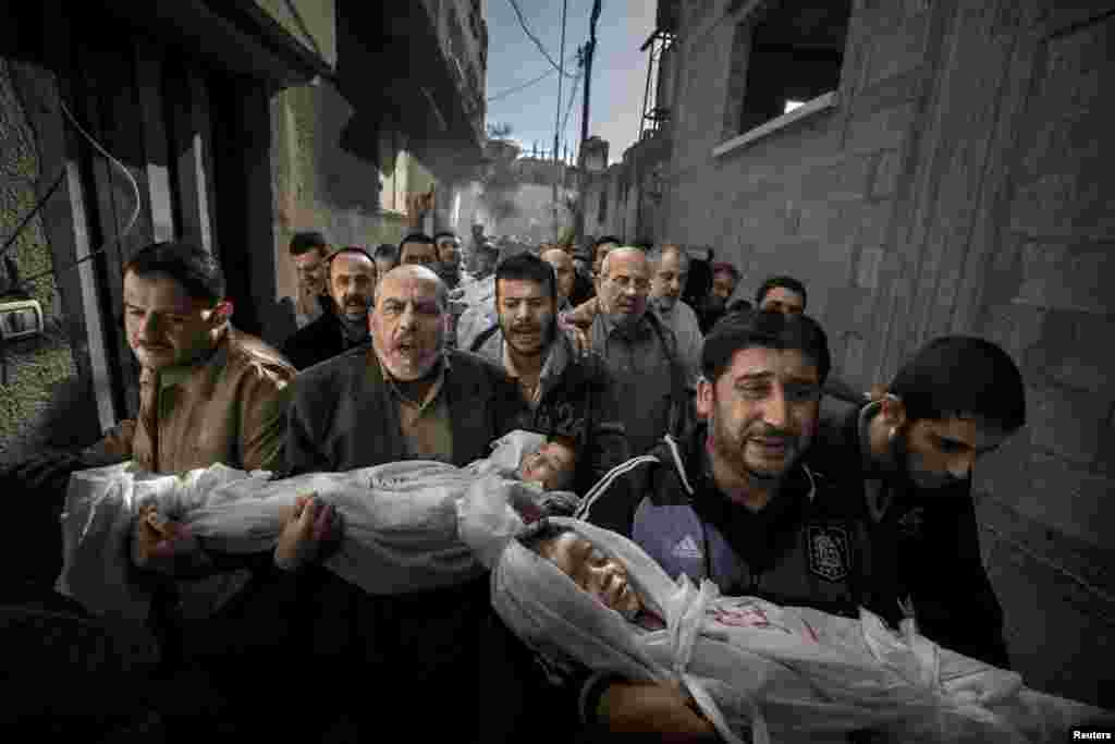 Победитель фотоконкурса World Press Photo 2013 в категории &laquo;Фотография года&raquo;. Газа. Двухлетняя Сухаиб Хиджази и её трёхлетний брат Мухаммад погибли, когда в их дом попал израильский снаряд. Их отец Фуад также погиб, а мать попала в отделение интенсивной терапии. Брат Фуада несёт тела детей к мечети, где пройдут похороны. (Paul Hansen/Sweeden/Dagens Nyheter) 