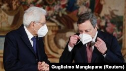 Mario Dragi namešta masku pored predsednika Italije Serđa Matarele (Sergio Mattarella ) posle ceremonije polaganja zakletve nove italijanske vlade, Rim, 13. februar 2021. 