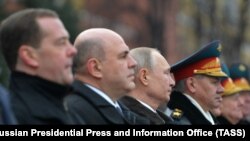 Владимир Путин (ўртада) амалдаги бош вазир Михаил Мишустин (чавдан иккинчи), собиқ бош вазир Дмитрий Медведев (чапда) ва мудофаа вазири Сергей Шойгу (чапдан тўртинчи) билан