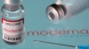 A vial labeled "Moderna coronavirus disease (COVID-19) vaccine" placed on displayed Moderna logo, March 24, 2021.