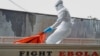 Liberia -- A Liberian health worker in a burial squad drags an Ebola victim's body for cremation from the ELWA treatment center in Monrovia, October 13, 2014