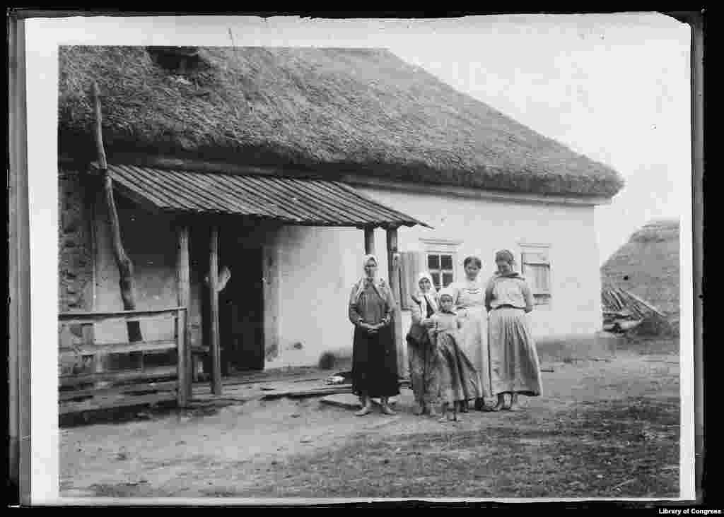 Це – фото американського Червоного Хреста, як мовиться в супровідному тексті, показує «типову хату в Малоросії» в листопаді 1919 року, хоча в наступному реченні згадано й «Україну». Далі в тексті хвалять українських селян за витривалість і винахідливість під час Першої світової війни, завдяки чому вони не так потерпали від труднощів, як у містах. У цій хаті американців прийняли гостинно