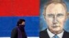 Një grua duke kaluar pranë një murali me portretin e presidentit rus, Vladimir Putin në Beograd. Fotografi ilustruese nga arkivi. 