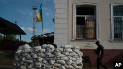Un membru al Serviciului de Stat pentru Situații de Urgență al Ucrainei intră în subsolul fortificat al gării folosit pentru anchete în timpul ocupației rusești în localitatea recucerită Kozacea Lopan, Ucraina, 18 septembrie 2022