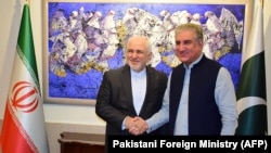 Pakistani Foreign Minister Shah Mehmood Qureshi (R) shakes hands with his Iranian counterpart Mohammad Javad Zarif at the Foreign Ministry in Islamabad on May 24.
