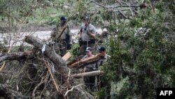 Căutând supraviețuitori pe malul râului Guadalupe la Kerrville, Texas, pe 6 iulie, la două zile după inundațiile locale dezastruoase. 