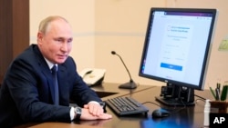 Рускиот претседател Владимир Путин присуствува на далечинско електронско гласање за време на парламентарните избори во резиденцијата Ново-Огариово надвор од Москва, 17 септември 2021 година.