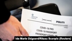 Një person mban certifikatën e vaksinimit kundër koronavirusit, të lëshuar nga autoritetet daneze.