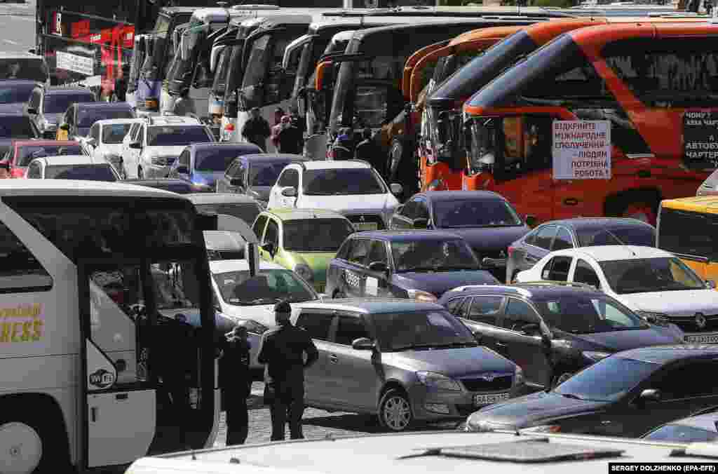 Autobuze și mașini parcate de proprietarii de afaceri mici în timpul unui protest la Kiev, Ucraina, în 13 mai, în care aceștia au cerut să li se permită să se întoarcă la muncă