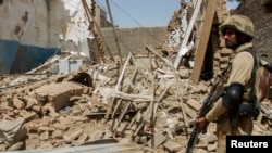 File photo of a Pakistani soldier standing near the debris of a house destroyed during a military operation in the town of Miranshah in North Waziristan.