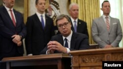 Претседателот на Србија Александар Вучиќ слуша додека американскиот претседател Доналд Трамп зборува за време на церемонијата на потпишување со косовскиот премиер Авдулах Хоти во Белата куќа во Вашингтон, САД, 4 септември 2020 година