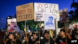 Familiile ostaticilor țin portrete ale celor răpiți de Hamas în timpul unui miting în fața birourilor UNICEF din Tel Aviv, pe 20 noiembrie 2023.