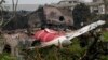 Părți dintr-un avion Air India prăbușit joi sunt văzute deasupra unei clădiri din Ahmedabad, India, vineri, 13 iunie 2025.