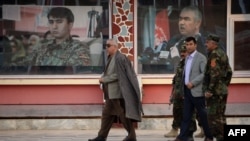 FILE: Afghan Vice President Abdul Rashid Dostum (L) walks at his headquarters in Sheberghan, capital of northern Jowzjan Province.
