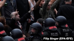 Protestatari de dreapta faţă în faţă cu polițiștii. 25 august 2018, în oraşul est-german Chemnitz