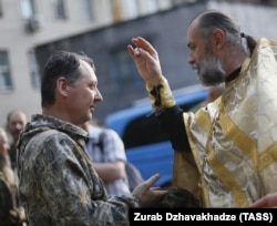Священик благословляє у Донецьку російського полковника Ігоря Гіркіна (Стрєлкова), одного з колишніх ватажків угруповання «ДНР», яке визнане в Україні терористичним. Липень 2014 року
