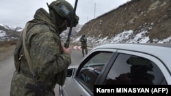 Nagorno-Karabakh - A Russian soldier of the peacekeeping force controls a vehicle at a checkpoint on a road outside Stepanakert, November 26, 2020.