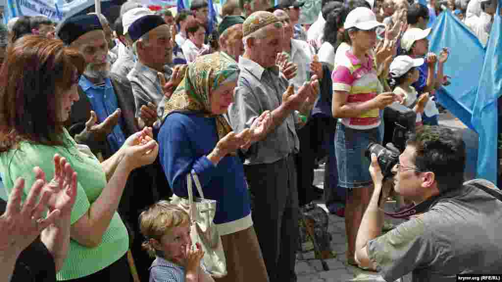 2007 senesi. Qırımtatarlar, halqnıñ sürgün etilmesine bağışlanğan matem mitinginden evel dua oquylar