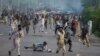 Anti-government protesters run after police personnel in Islamabad, September 1, 2014.