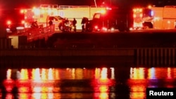 Vehicule ale forțelor de salvare, pe malul râului Potomac, după accidentul aerian, 29 ianuarie 2025.