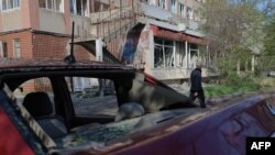 Un bărbat trece pe lângă o clădire avariată în urma unui atac cu drone rusești în Odesa, pe 22 aprilie 2025.