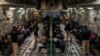 Migranții reținuți așteaptă decolarea într-un zbor C-17 Globemaster III al Forțelor Aeriene ale SUA pe Aeroportul Internațional Tucson din Tucson, Arizona, 23 ianuarie 2025.