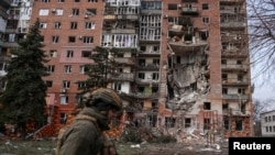 Ukrán katona egy lebombázott lakóház előtt Pokrovszkban 2025. március 6-án