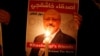 FILE: A demonstrator holds a poster with a picture of Saudi journalist Jamal Khashoggi outside the Saudi Arabia consulate in Istanbul in October.
