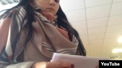 Жанчына зь некалькімі бюлетэнямі на выбарчым участку ў Берасьці, якую спыніў назіральнік. Кадр зь відэа Юрыя Вашчанчука