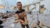 Un palestinian ține în mână paste la locul unui atac israelian asupra unui depozit de ajutoare, în tabăra de refugiați Al-Nuseirat din centrul Fâșiei Gaza. Reuters, 14 martie 2024.