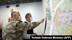 Илустрација, турскиот министер за одбрана Халуси Акар гледа во одредени таргети на воена операција